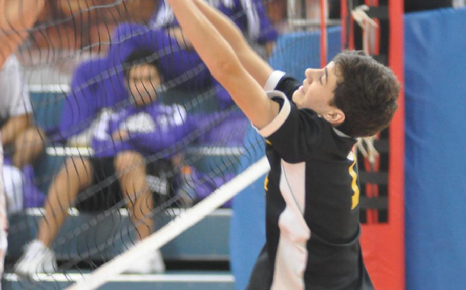 Vicenza junior Michael DeOliveria pushes the ball over the net despite opposition from an American Overseas School of Rome defender during pool play Friday at the DODDS-Europe boys volleyball championships. Vicenza won 25-20, 20-25, 25-23 to clinch a spot in the semifinals held later Friday.