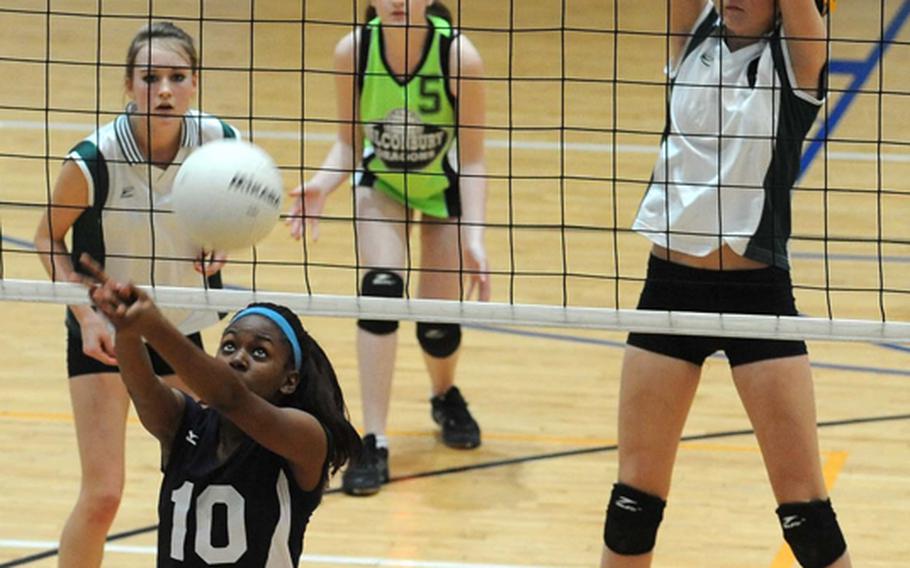 Menwith Hill's Alexis Thomas returns a ball as Alconbury's Ashley Goluba, Riley Sorensen and Savanna Fourham, from left, defend.  Menwith Hill won the Division III semifinal 25-19, 25-21, 23-25, 30-28, and will face Rota in Saturday's final at the DODDS-Europe volleyball championships.