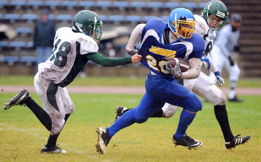 Sigonella's Jeff Lastrella rushes for a big gain before Alconbury's Justin Thibodeua, left, and Cameron Hall can bring him down. Lastrella scored the Jaguars' third touchdown of the day a few plays later, on their way to winning the Division III crown with a 19-12 win.