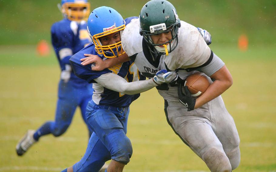 Sigonella's Marco Montero, left, can't stop Alconbury's Kerey Kuheana from scoring the Dragons' first touchdown. Kuheana's efforts were for naught, however, as the Jaguars beat Alconbury, 19-12, to take the Division III crown.