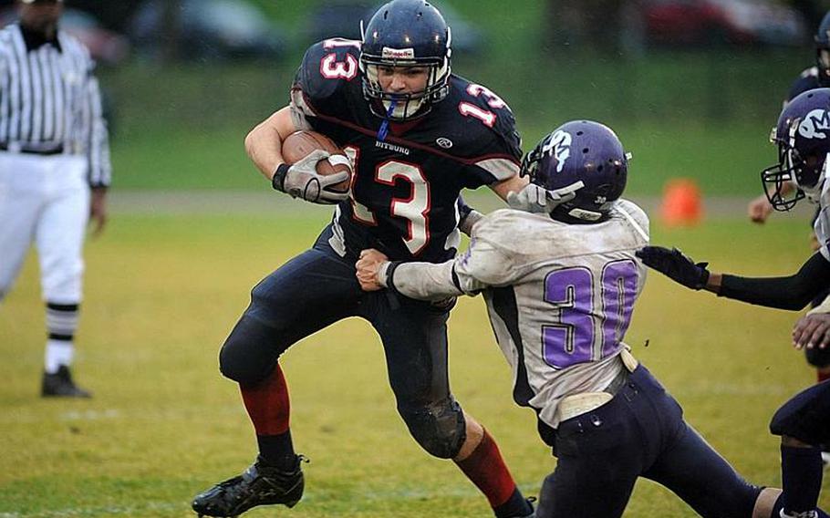 Bitburg's Kyle Edgar tries to keep Mannheim's Jacob Lankford at arm's length as he picks up yardage. Bitburg defended its Division II title with a 34-7 win over Mannheim on Saturday.