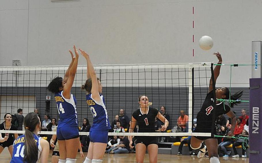 Vilseck junior Mariah Morris tries to spike the ball past  Wiesbaden senior LeAmber Thomas, left, and sophomore Kirsten Velsvaag during Saturday's Division I championship game at Ramstein Air Base.  Vilseck flew past the Warriors to claim the title.