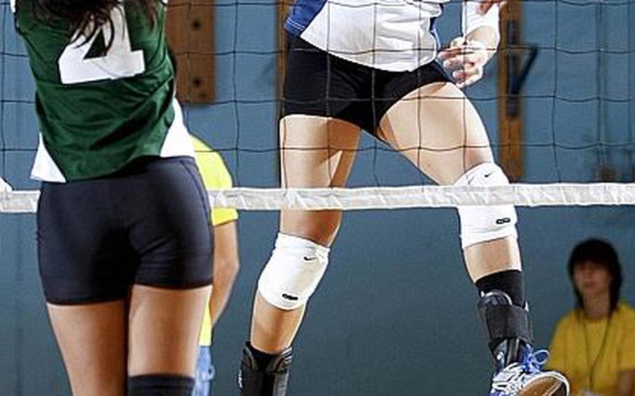 Seoul American's Liz Gleaves lets a spike kill fly past Lyka Eata of Guam's John F. Kennedy during Monday's pool-play matches in the Far East High School Division I Girls Volleyball Tournament at Falcon Gym, Seoul American High School, South Post, Yongsan Garrison, South Korea. The Falcons won 25-16, 25-13.