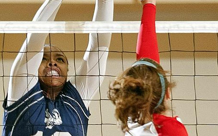 Seoul American's Destinee Harrison, left and Nile C. Kinnick's Emily Stith battle for the ball at the net during Tuesday's division-play match in the Far East High School Girls Division I Volleyball Tournament at Super Gym, Camp Humphreys, South Korea. Kinnick won, 25-23, 25-16.