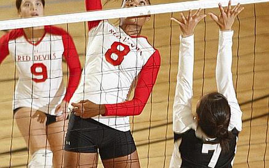 Nile C. Kinnick's Mashiya McKinney readies a spike against Regina Shiroma of Simon Sanchez during Tuesday's division-play match in the Far East High School Girls Division I Volleyball Tournament at Super Gym, Camp Humphreys, South Korea. Kinnick split with Simon Sanchez, losing 25-24 and winning 25-20.