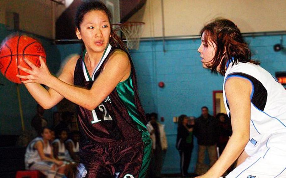 Senior guard Gulee Kwon (12), being defended by Courtney Ouellette of Osan American, is one of six players returning to a Warriors team that will defend the Far East Girls Division II Basketball Tournament title in February on its home floor.