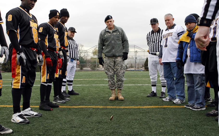 Yongsan Garrison command Sgt. Maj. Ralph Rusch, center, in uniform, and Maj. Gen. Mark Gurganus (1), Marine Forces Korea commanding officer, preside over the pre-game coin toss prior to Saturday's Army-Navy flag football game at Sims Field, Seoul American High School, South Korea. Army prevailed over Navy 12-6 in overtime.