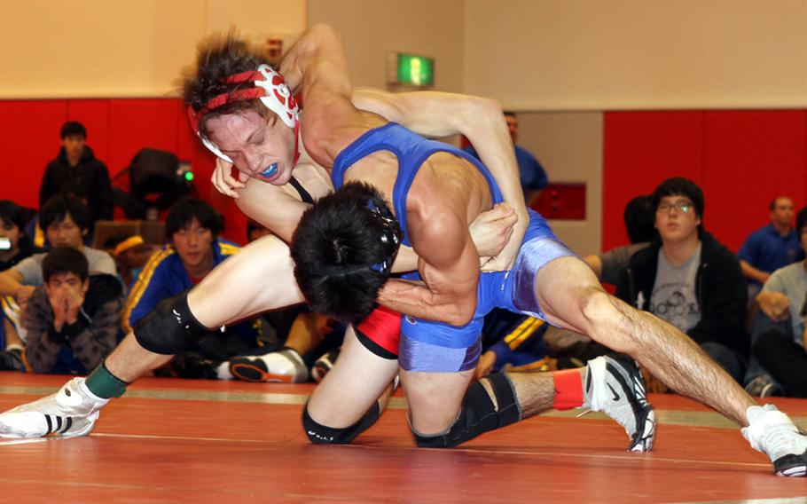 Two-time Far East tournament weight-class gold-medalist Marcus Boehler of Nile C. Kinnick battles Kelly Langley of St. Mary's International for the upper hand during Saturday's 122-pound championship bout in the Japan High School Preseason Wrestling Tournament at Nile C. Kinnick High School, Yokosuka Naval Base, Japan. Langley decisioned Boehler 2-0 (6-3, 4-3).