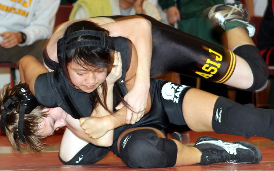 Zama American senior Yurie Tanaka begins to gain a head-in-arm hold on American School In Japan freshman Callan Murphy during Saturday's 108-pound championship bout in the Japan High School Preseason Wrestling Tournament at Nile C. Kinnick High School, Yokosuka Naval Base, Japan. Tanaka pinned Murphy in 1 minute, 35 seconds, becoming just the second girl wrestler to win a gold medal in a Japan tournament, joining Alyssa Rodriguez of Robert D. Edgren four seasons ago.