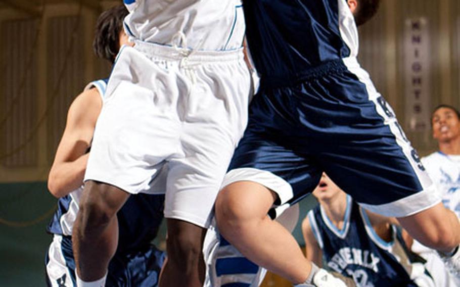 Tomiwa Akinbayo of Seoul American battles Korea International's Jae Wook Lee for a rebound during Wednesday's Korean-American Interscholastic Activities Conference Boys Division I basketball game at Seoul American High School, South Korea. The Falcons beat the Phoenix 57-17.