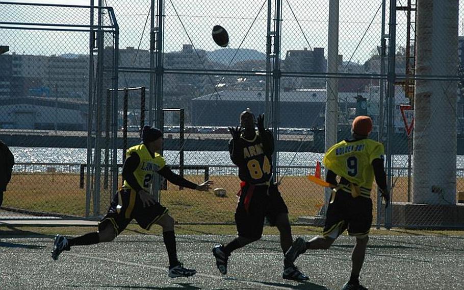 Between Navy defenders, Army's Jacobie Brydson concentrates on catching a deep pass during Army's 26-19 win over Navy Saturday at Yokosuka Naval Base during the annual Army-Navy flag football game pitting soldiers against sailors stationed on mainland Japan.