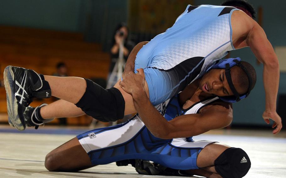 Eric Bush of Seoul American lifts Mark Tortillas of Osan American in a head-in-arm hold during Saturday's 129-pound bout in a DODDS-Korea wrestling tri-meet at Seoul American High School, South Korea. Bush superior decisioned Tortillas 2-0 (7-0, 8-2) and Seoul American won the dual meet, 41-6.