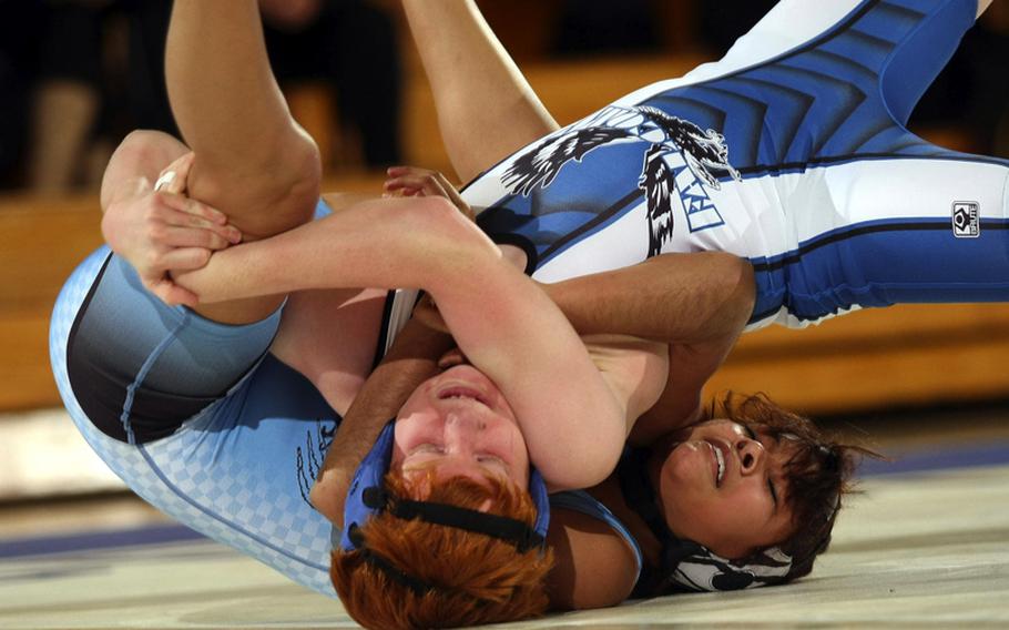 Devin Furner, left, of Seoul American tries to wrench the shoulders of Osan American's Janellis Collins during Saturday's 122-pound bout in a DODDS Korea wrestling tri-meet at Seoul American High School,  South Korea. Furner superior decisioned Collins 2-0 (7-0, 6-0) and Seoul American won the dual meet, 41-6.