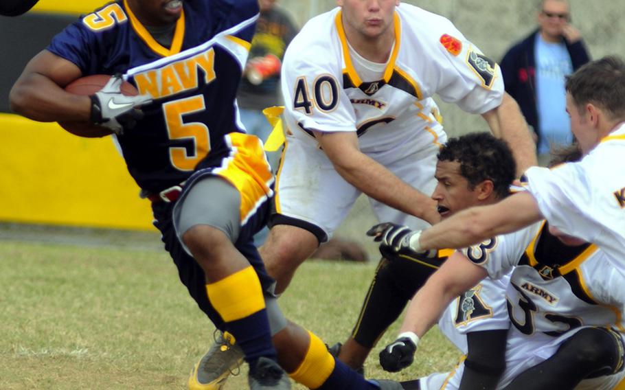 Navy running back Ricky Luttimore tries to elude Army defenders Justin Morton, from left,, Ryan Ashazahur, Jonathan Greathouse and Thomas Kerfoot during Saturday's Army-Navy flag football game at Torii Field, Torii Station, Okinawa. Navy broke a six-year losing streak in the 21-year-old series, beating Army, 27-3.