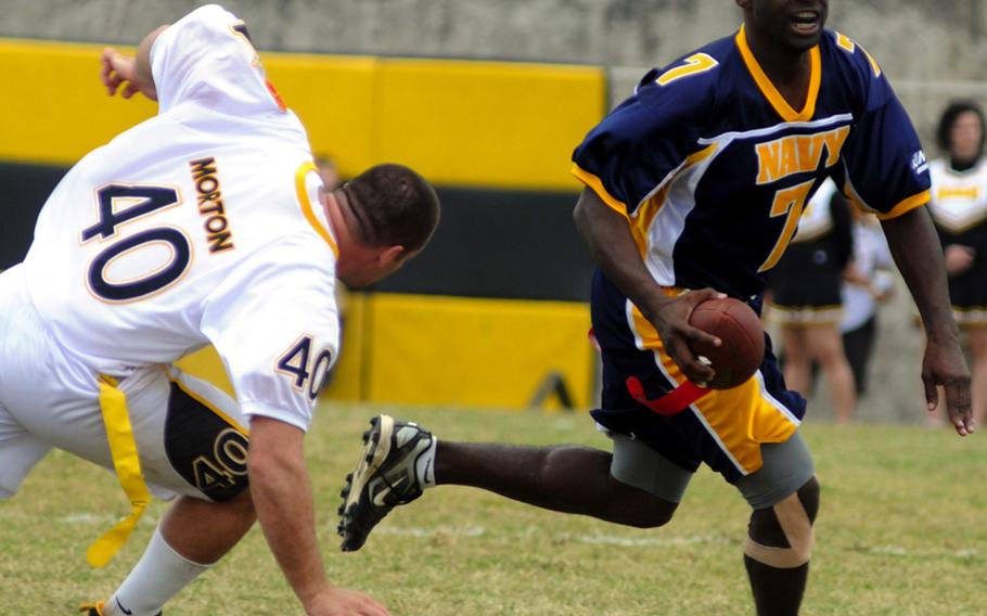 Navy quarterback Robert Trisby looks to throw as Army defender Justin Morton gives chase during Saturday's Army-Navy flag football game at Torii Field, Torii Station, Okinawa. Trisby was named the game's Most Valuable Player and Navy broke a six-year losing streak in the 21-year-old series, beating Army, 27-3.