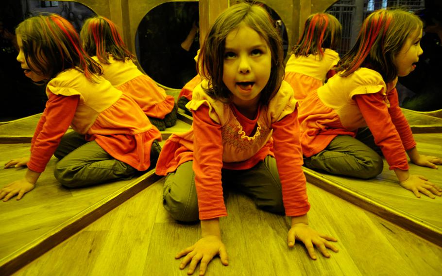 Anna Barse, 6, from Stuttgart, climbs through a mirrored room in the castle of Sensapolis.