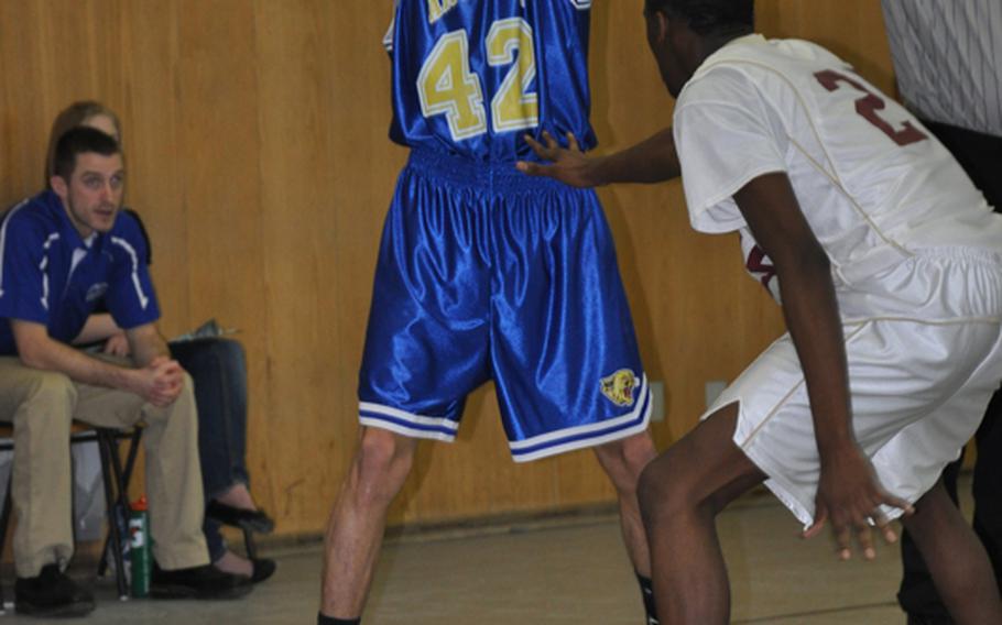 Ansbach junior Herivan Figueroa looks for an open teammate Saturday during the Cougars' 62-52 win over visiting Baumholder. Figueroa scored 14 points, collected 6 rebounds, and had 5 steals in the Cougars' first win of the season.