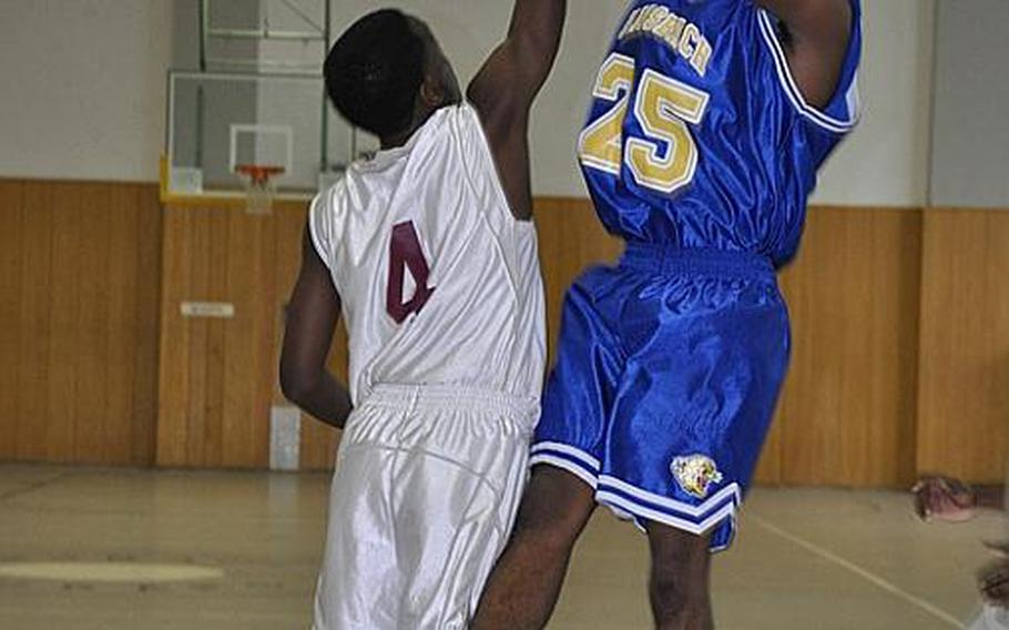 Junior Derrick Flake of Ansbach takes a shot over a Baumholder defender Saturday during the Cougars' first win of the season against the visiting Bucs, 62-52. Flake led the team in scoring with 35 points.