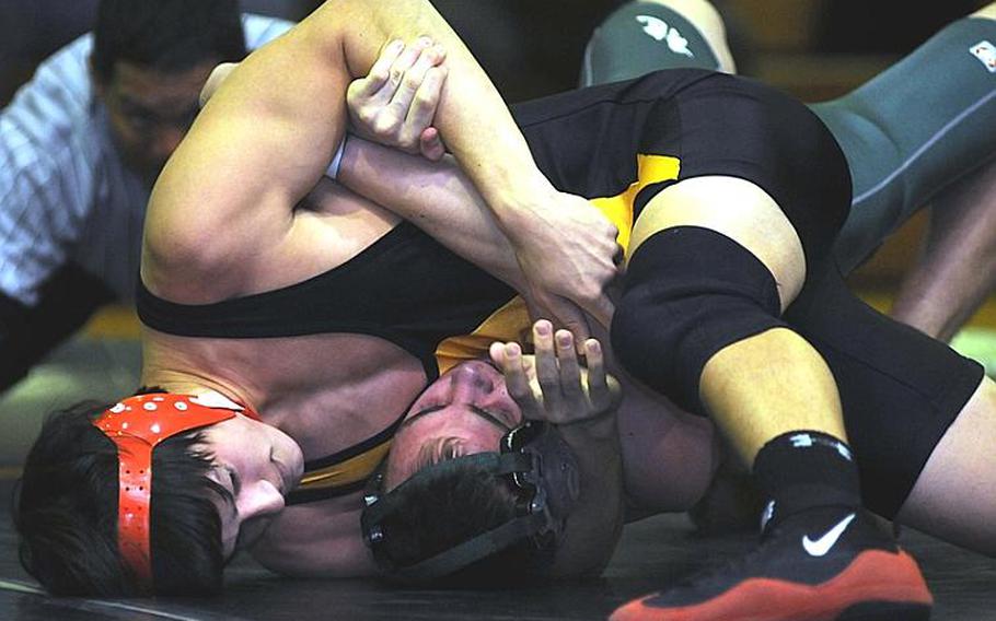 Kadena's Jeff Mizell wrenches the shoulders of Kubasaki's Austin Standridge toward the mat during Thursday's 135-pound bout in the Okinawa Activities Council dual meet at Kadena High School, Okinawa. Mizell pinned Standridge in 1 minute, 45 seconds, but Kubasaki won the dual meet, 36-28.