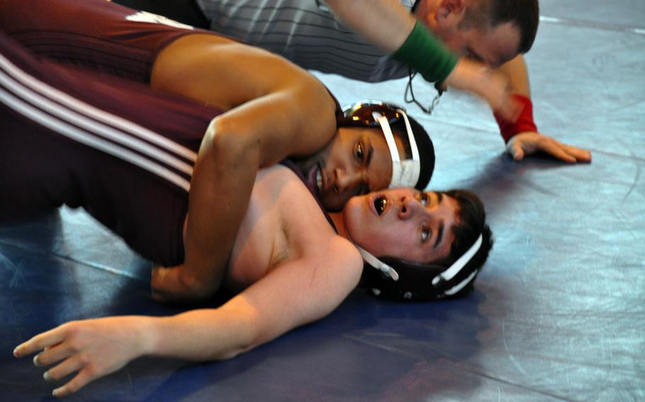 Isaiah McNickles of Vilseck pins his teammate, Kyle Hightower, during a 152-pound matchup Saturday in Ansbach. Referee Brian Schramm prepares to signal the end of the match.