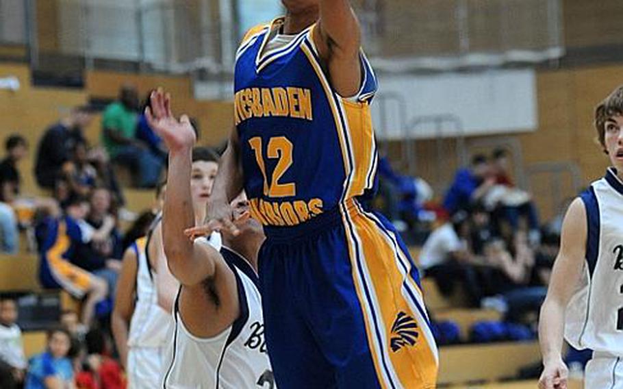 Wiesbadens Roscoe Johnson, left, gets past Bitburg's J.B. Tarnate-Jones for two of his 10 points during the Warriors' 62-45 win over the visiting Barons on Saturday.