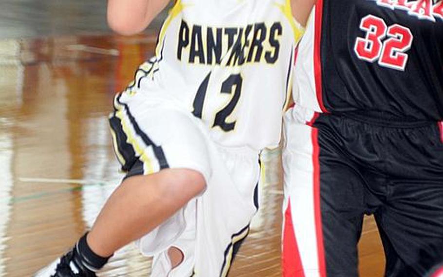 Heather Brown of Kadena High School drives to the basket against Kimberly Olton of Lady Ballaz during Sunday's double-elimination championship bracket game in the 17th Martin Luther King Invitational Basketball Tournament at Camp Foster, Okinawa. Lady Ballaz beat Kadena High, 65-18, hours after the Panthers beat the aircraft carrier USS George Washington, 87-86 in triple-overtime, the highest-scoring women's game in Foster Field House history.