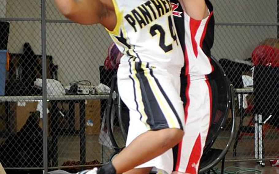 Mariah Harris of Kadena High School looks to pass against Lady Ballaz defender Brittany Newsom during Sunday's double-elimination championship bracket game in the 17th Martin Luther King Invitational Basketball Tournament at  Camp Foster, Okinawa. Lady Ballaz beat Kadena High, 65-18, hours after the Panthers beat the aircraft carrier USS George Washington, 87-86 in triple-overtime, the highest-scoring women's game in Foster Field House history.