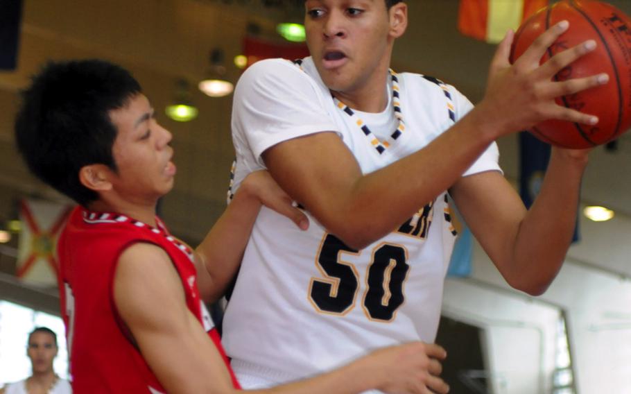 Kadena Panthers sophomore Jaylen Street holds the ball away from a Chatan defender during Saturday's pool-play in the 5th Okinawa-American Shootout basketball tournament at Camp Foster, Okinawa. Kadena won, 59-22, and earned the top seed out of Pool B into the double-elimination playoffs; the Panthers then beat Koza, 103-63, to advance to Sunday's semifinal.