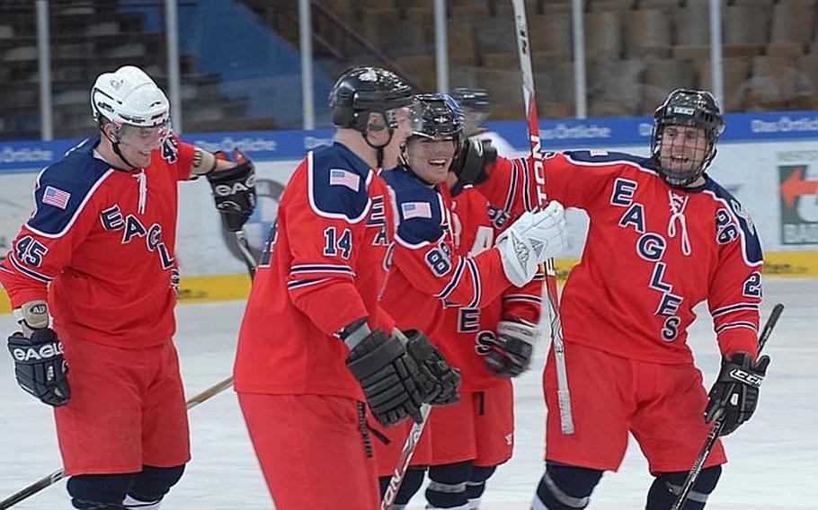 Mike Becker of the KMC Eagles, center, is surrounded by teammates after scoring the opening goal in his team's 6-2 win against the Geilenkirchen Flyers in the title game of the U.S. Forces Ice Hockey Championship tournament in Garmisch, Germany, on Saturday.