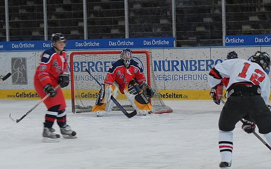 KMC goalie Josh Taylor keeps his eye on the puck as a member of the Geilenkirchen Flyers prepares to launch a shot. Taylor held the Flyers to two goals as the KMC Eagles won the title game of the U.S. Forces Ice Hockey Championship, 6-2, in Garmisch, Germany, on Saturday.