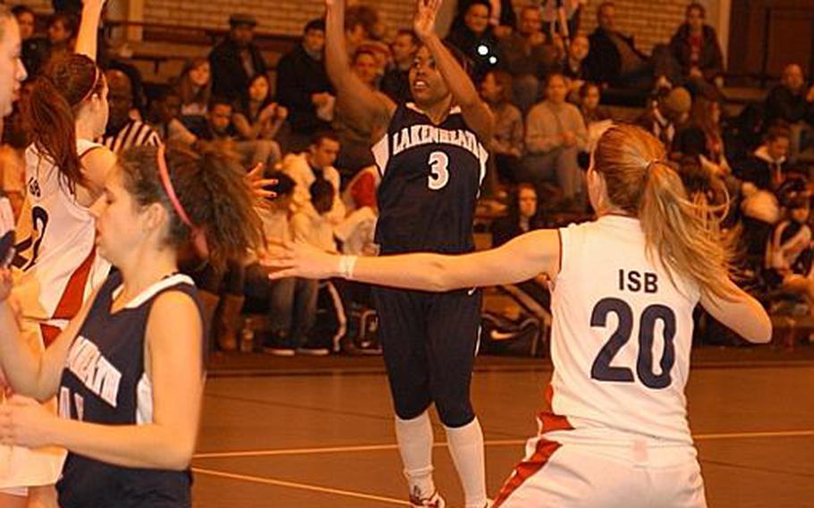 Lakenheath's Jasmin Walker takes a shot from beyond the three-point line during a game against International School of Brussels. Lady Raiders defender Vanessa Sepul moves into position for a possible rebound. Walker finished with 16 points as Lakenheath won, 40-21.