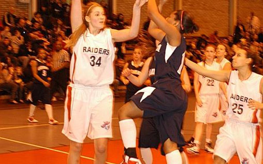 Lakenheath's Shaionica Speight puts up a shot between International School of Brussels defenders Lucie Wollenstein, left, and Mirian Chaibi.