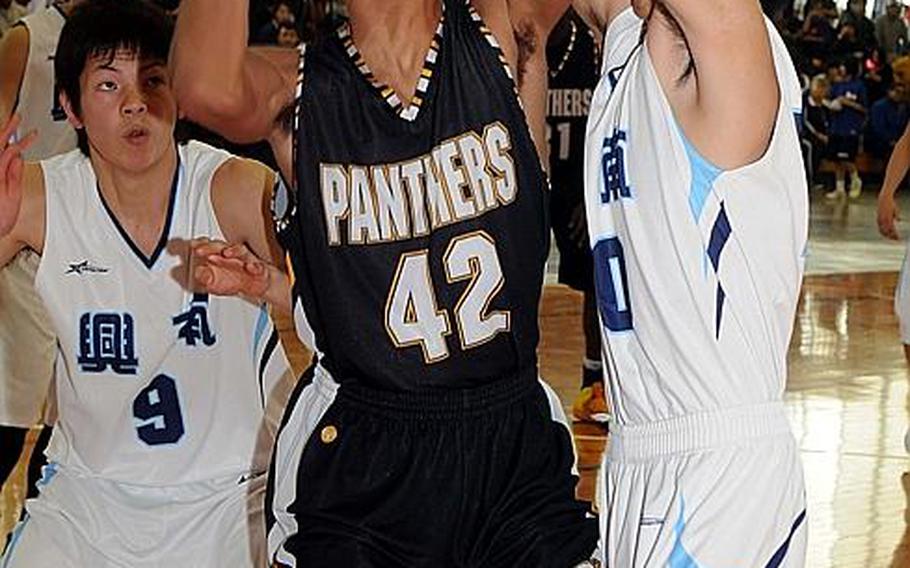 Kadena Panthers senior Jason Sumpter finds his way to the basket clogged by Konan defenders during Sunday's boys championship game in the 5th Okinawa-American Shootout basketball tournament at Camp Foster, Okinawa. Konan, Okinawa Prefecture's No. 1-rated team, routed Kadena, 86-52, for its second straight title in the tournament.