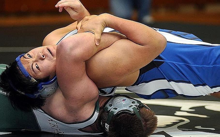 Seoul American's Aaron Park turns the shoulders of Kubasaki's Jacob Wood to the mat during Friday's 215-pound bout in the dual-meet portion of the 4th Rumble on the Rock high school wrestling tournament at Kubasaki High School, Okinawa. Wood rallied to win by pin in 2 minutes, 50 seconds, and Kubasaki beat Seoul American, 39-19.