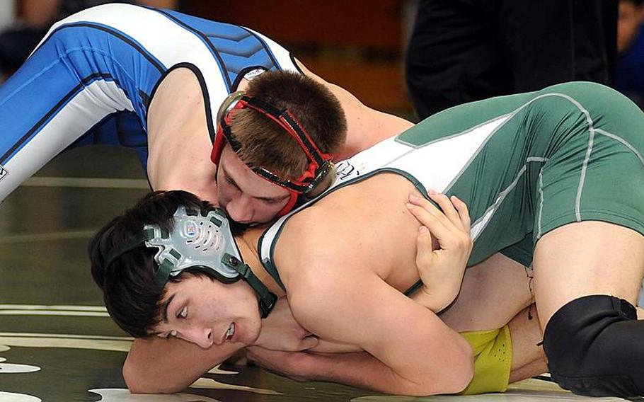 Seoul American Falcons junior 129-pound wrestler Robert Rhea, top, works toward a victory by decision over Kubasaki's Mark Chase in Saturday's gold-medal bout in the 4th Rumble on the Rock wrestling tournament at Kubasaki High School, Okinawa.