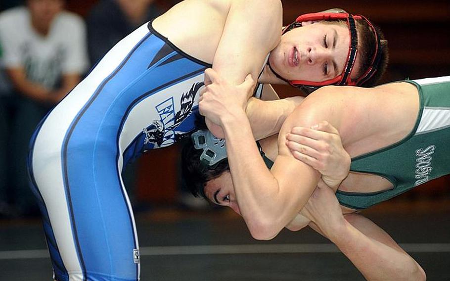 Seoul American Falcons junior 129-pound wrestler Robert Rhea, top, works toward a victory by decision over Kubasaki's Mark Chase in Saturday's gold-medal bout in the 4th Rumble on the Rock wrestling tournament at Kubasaki High School, Okinawa.