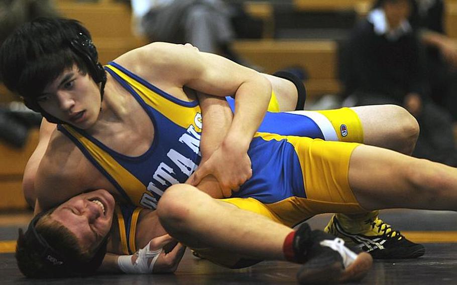 Yokota's Josh Chamberlain grimaces as Brendan Hymas of St. Mary's International secures a head-in-arm hold during Wednesday's 148-pound bout in the Kanto Plain Association of Secondary Schools' regular-season finale at St. Mary's International School, Tokyo. Hymas pinned Chamberlain in 3 minutes, 26 seconds and St. Mary's beat Yokota, 38-25, to force a three-way tie atop the Kanto final regular-season standings with Zama American at 4-1.