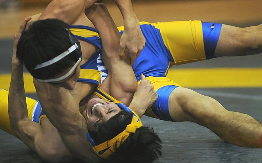 Yokota's Phil Robles grimaces and tries to fight his way out of a head-in-arm move by Soma Yoshida of St. Mary's International during Wednesday's 115-pound bout in the Kanto Plain Association of Secondary Schools' regular-season finale at St. Mary's International School, Tokyo. Yoshida pinned Robles in 3 minutes, 2 seconds and St. Mary's beat Yokota, 38-25, to force a three-way tie atop the Kanto final regular-season standings with Zama American at 4-1.