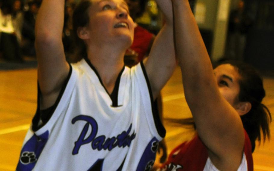 Yokota's Kathryn White puts up a shot against Dusty Keolanui-Wilson of Nile C. Kinnick during Saturday's girls championship game in the 5th DODDS- Japan basketball tournament at Yokota High School, Japan. Yokota won, 53-28.