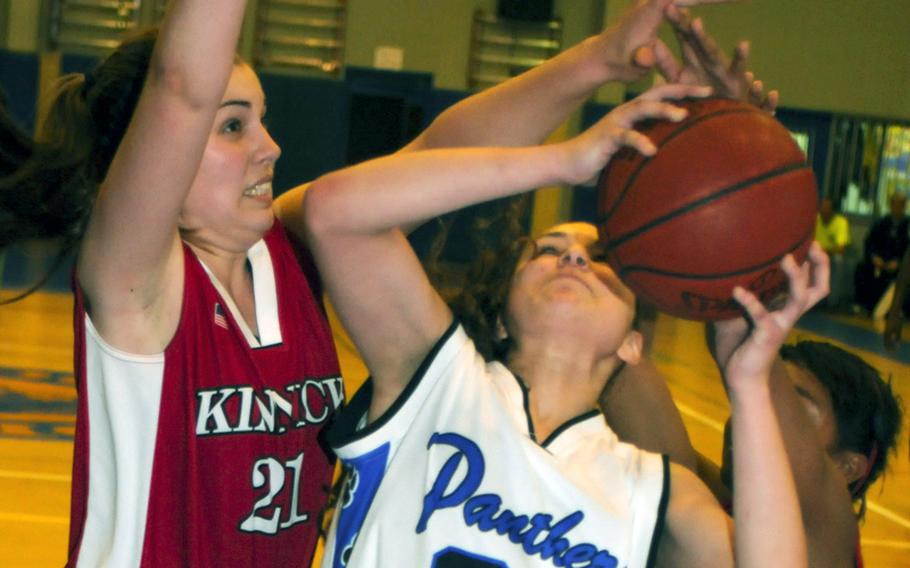 Yokota's Sydney Glover has her shot contested by Nile C. Kinnick defenders Emily Stith, left, and Erica Carter during Saturday's girls championship game in the 5th DODDS-Japan basketball tournament at Yokota High School, Japan. Yokota won, 53-28.