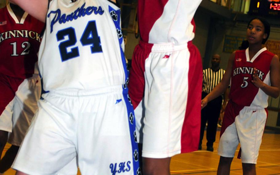 Yokota's Julia Marrin, the tournament MVP, has her shot contested by Mashiya McKinney of Nile C. Kinnick during Saturday' girls championship game in the 5th DODDS-Japan basketball tournament at Yokota High School, Japan. Yokota won, 53-28.