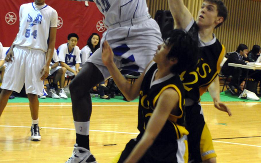 Seoul American's Tomiwa Akinbayo loses the handle on the ball against Taejon Christian International defenders Jin Do and Levi Miller during Friday's game in the 2011 Korean-American Interscholastic Activities Conference Boys Division I Basketball Tournament at Gyeonggi Suwon International School, South Korea. Seoul American routed TCIS, 80-49.