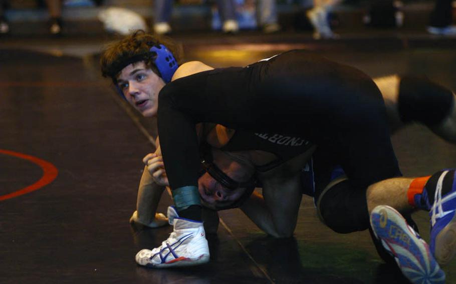 Brussels wrestler Dakota Deverill looks to his coaches for advice while AFNORTH's Nate Flynn tries to free himself during a match in the 152-pound weight division at the DODDS-Europe Northern Sectionals.