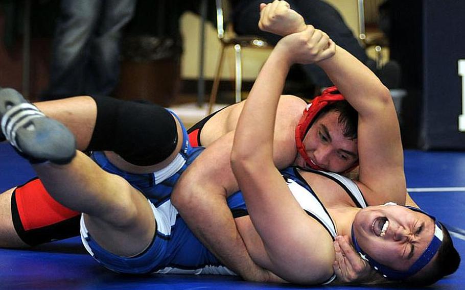 Seoul American&#39;s Matt Choi grimaces as Nile C. Kinnick&#39;s David de los Santos gains the advantage during Tuesday&#39;s 215-pound quarterfinal bout in the 34th Far East High School Wrestling Tournament at Super Gym, Camp Humphreys, South Korea. De los Santos decisioned Choi 2-0 (3-0, 7-4).