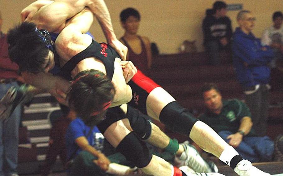 Three-time Far East gold medalist Marcus Boehler of Nile C. Kinnick tosses St. Mary's Kelly Langley out of bounds with a right shoulder throw during Wednesday's 122-pound gold-medal bout in the 34th Far East High School Wrestling Tournament at Super Gym, Camp Humphreys, South Korea. Boehler decisioned Langley 2-0 (4-0, 7-0).