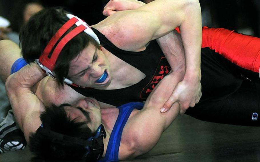 Three-time Far East gold medalist Marcus Boehler wrenches the shoulders of St. Mary's Kelly Langley toward the mat during Wednesday's 122-pound gold-medal bout in the 34th Far East High School Wrestling Tournament at Camp Humphreys, South Korea. Boehler decisioned Langley 2-0 (4-0,7-0).