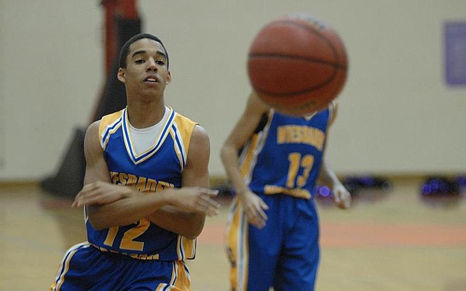 Wiesbaden sophomore Roscoe Johnson dishes off the ball during Friday night's game against Mannheim Bison on Friday. Mannheim won, 55-53, in the final regular-season game for the school, which is closing.