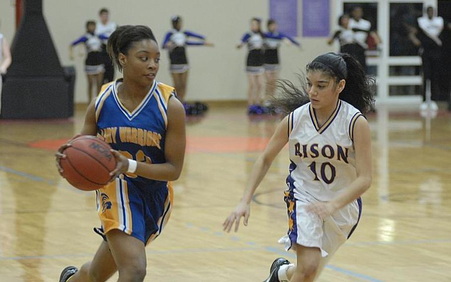 Wiesbaden senior Kelley Colbert dribbles past Mannheim sophomore Grace Gonzalez on Friday night at Mannheim's Benjamin Franklin Village Sports Arena.  The Lady Warriors won the game, 44-24, to remain undefeated on the season.  It was the final regular-season girls basketball game for Mannheim High School, which is closing.