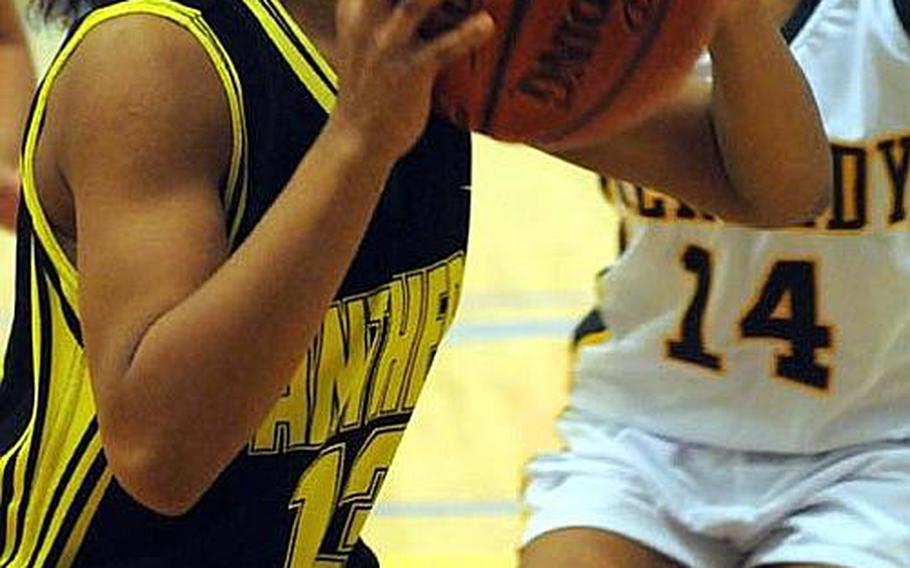 Kadena&#39;s Shari Moss puts up a shot as John F. Kennedy&#39;s Jennifer Abrincia watches during Tuesday&#39;s pool-play game in the Far East High School Girls Division I Basketball Tournament at Charles King Fitness & Sports Center, Naval Base Guam. Kadena won 50-20.