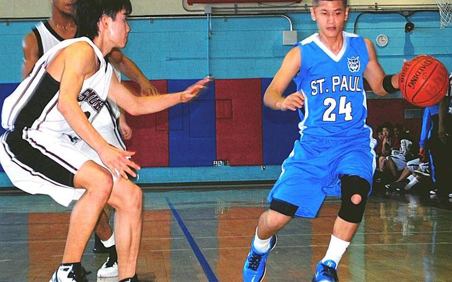 St. Paul Christian&#39;s Kory Borja (24) dribbles against John Ayers and Tairi Battig of Matthew C. Perry during Tuesday&#39;s pool-play game in the Far East High School Boys Division II Basketball Tournament at Kelly Fitness & Sports Center, Camp Walker, South Korea. St. Paul beat M.C. Perry 41-28.